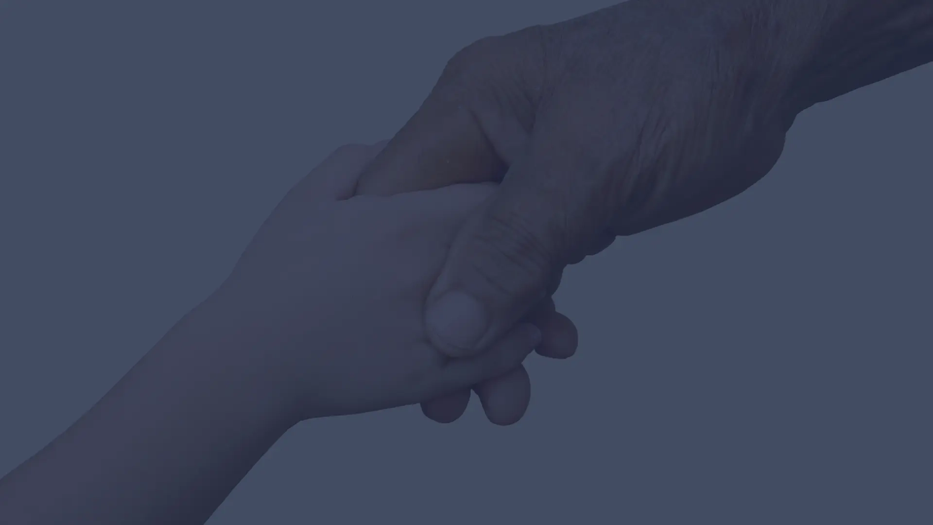 A caregiver gently holding the hands of a person receiving skin care